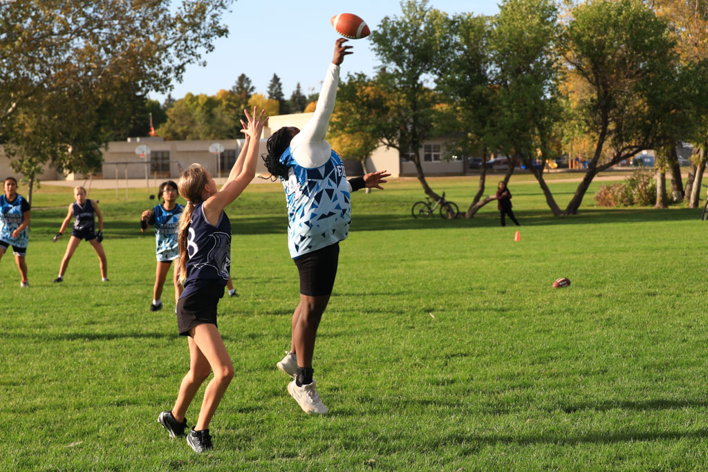 A battle for the football. One girl leaps in front of a forward pass